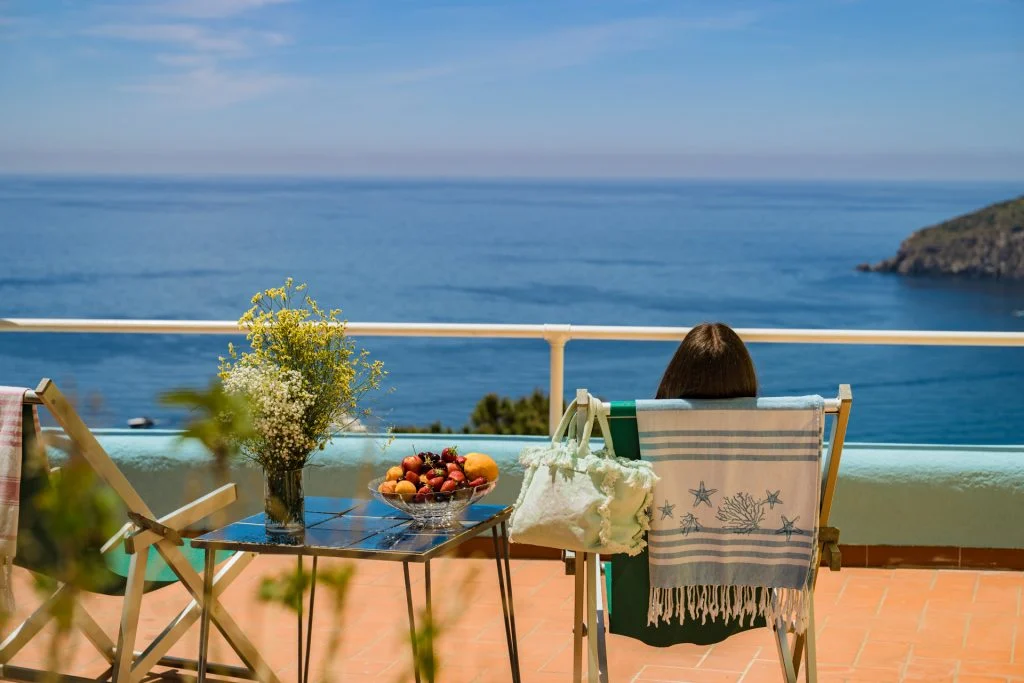 Un tavolino apparecchiato sulla terrazza vista mare dei Maronti