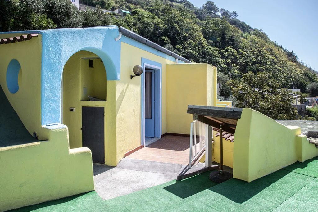 Gli esterni gialli e azzurri dell’hotel, tra il verde