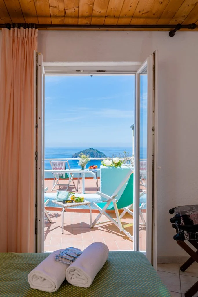 La porta finestra di una camera aperta sul balcone e sul mare